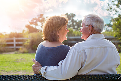Older couple sitting on bench outside