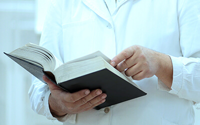 Doctor doing research while reading a book